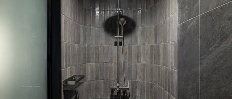 A modern shower with a handheld showerhead and a wall-mounted faucet.