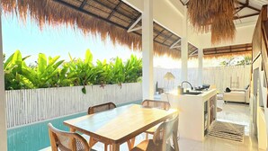 Un interior moderno con comedor, cocina y vistas a una piscina.