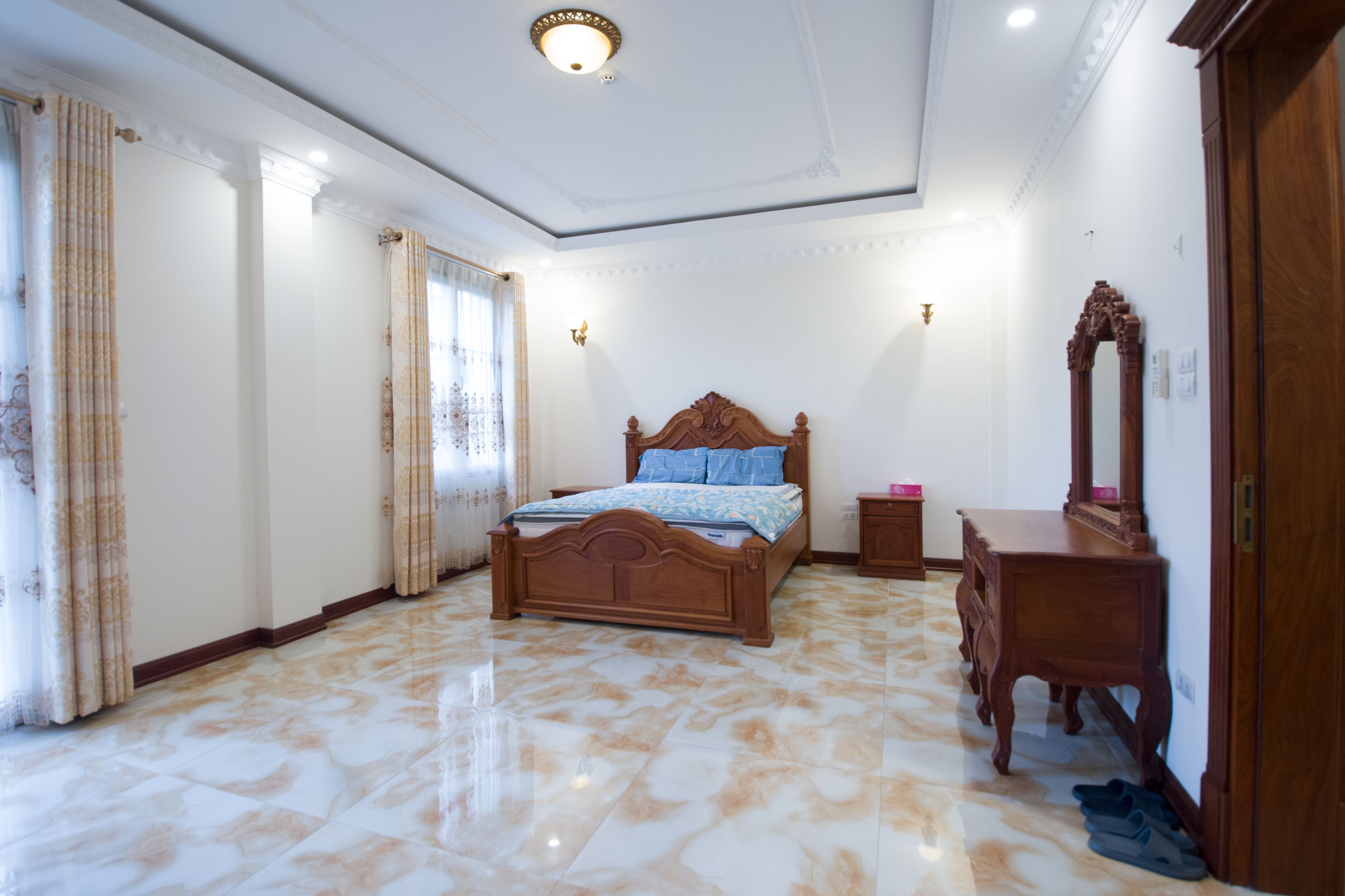 A bedroom with a wooden bed, a nightstand, a dresser, and a mirror.