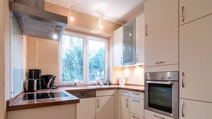 Una cocina moderna con horno integrado, cafetera y ventana que proporciona luz natural.