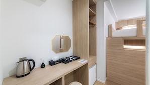 A compact room with a wooden desk, a kettle, a mirror, and a compact shelving unit. - Hi Stay Myeongdong (Seoul)