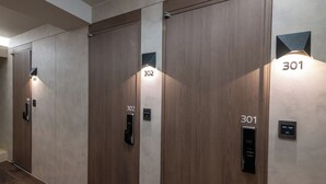 A row of wooden doors with digital lock systems, each labeled with a room number. - Hi Stay Myeongdong (Seoul)