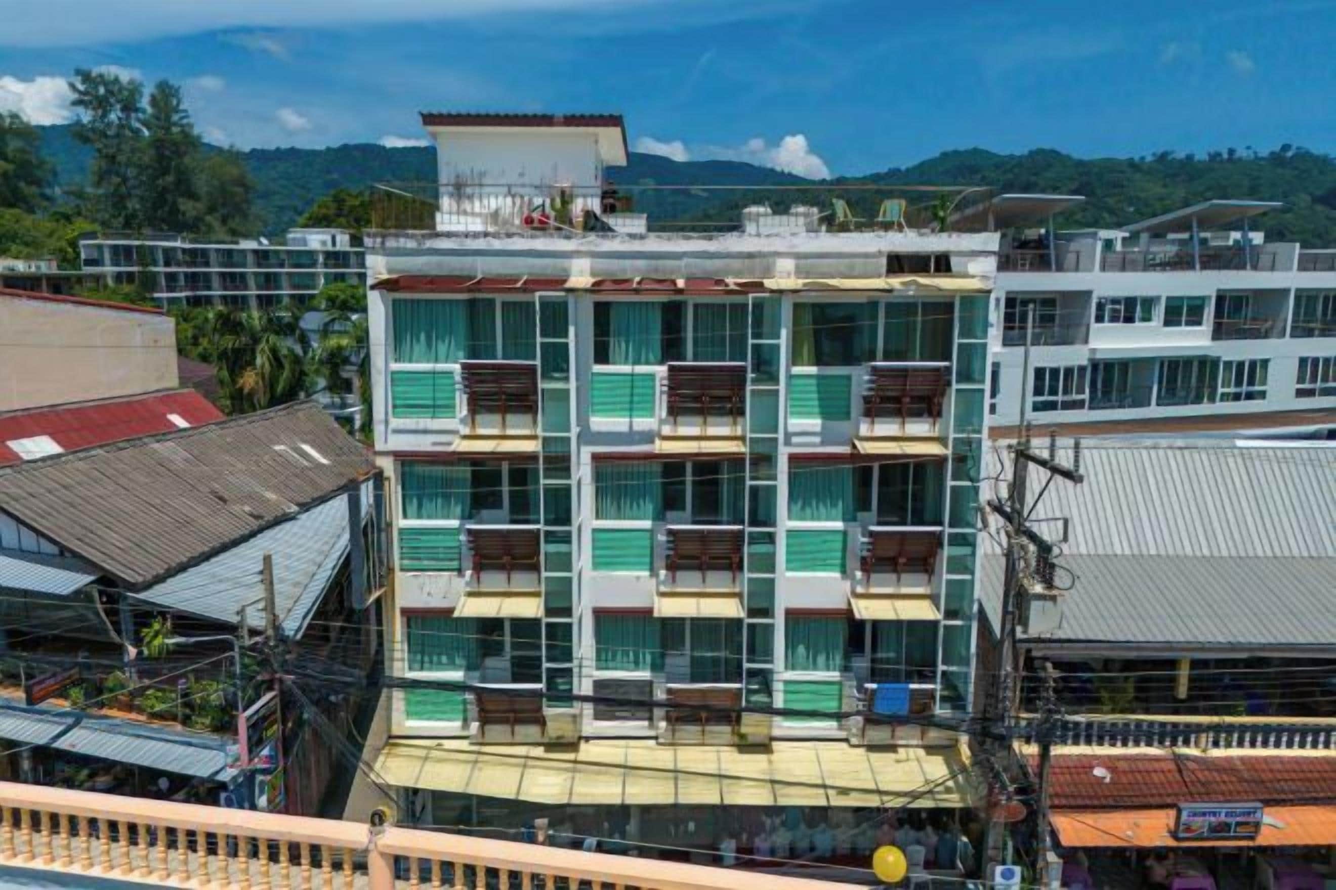 A multi-story building with balconies, a flat roof, and a view of the surrounding area.