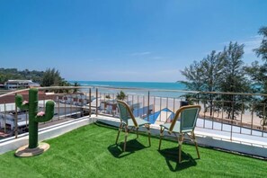 A balcony with artificial grass, two chairs, and a cactus decoration. - Catnip Seaside Hotel&Cafe (Phuket)