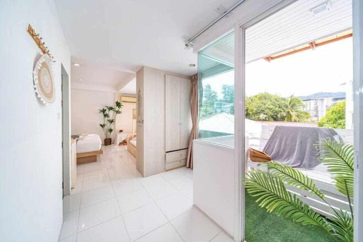 A modern bedroom with a bed, a wardrobe, and a large window with a view of the outside.