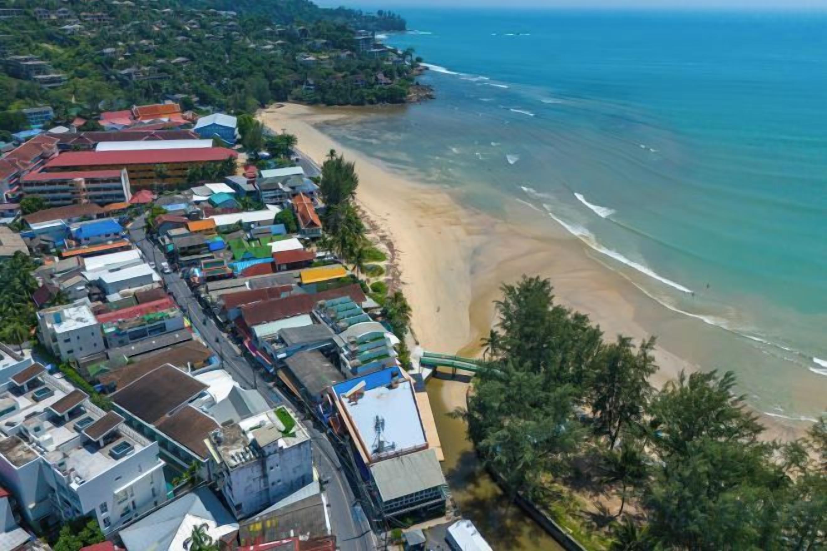 Une ville côtière dotée d’une plage, de bâtiments et offrant une vue dégagée sur l’océan.