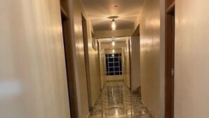 A hallway with a marble floor and doors on both sides. - Sophie's Garden Hotel Kapenguria (Makutano)