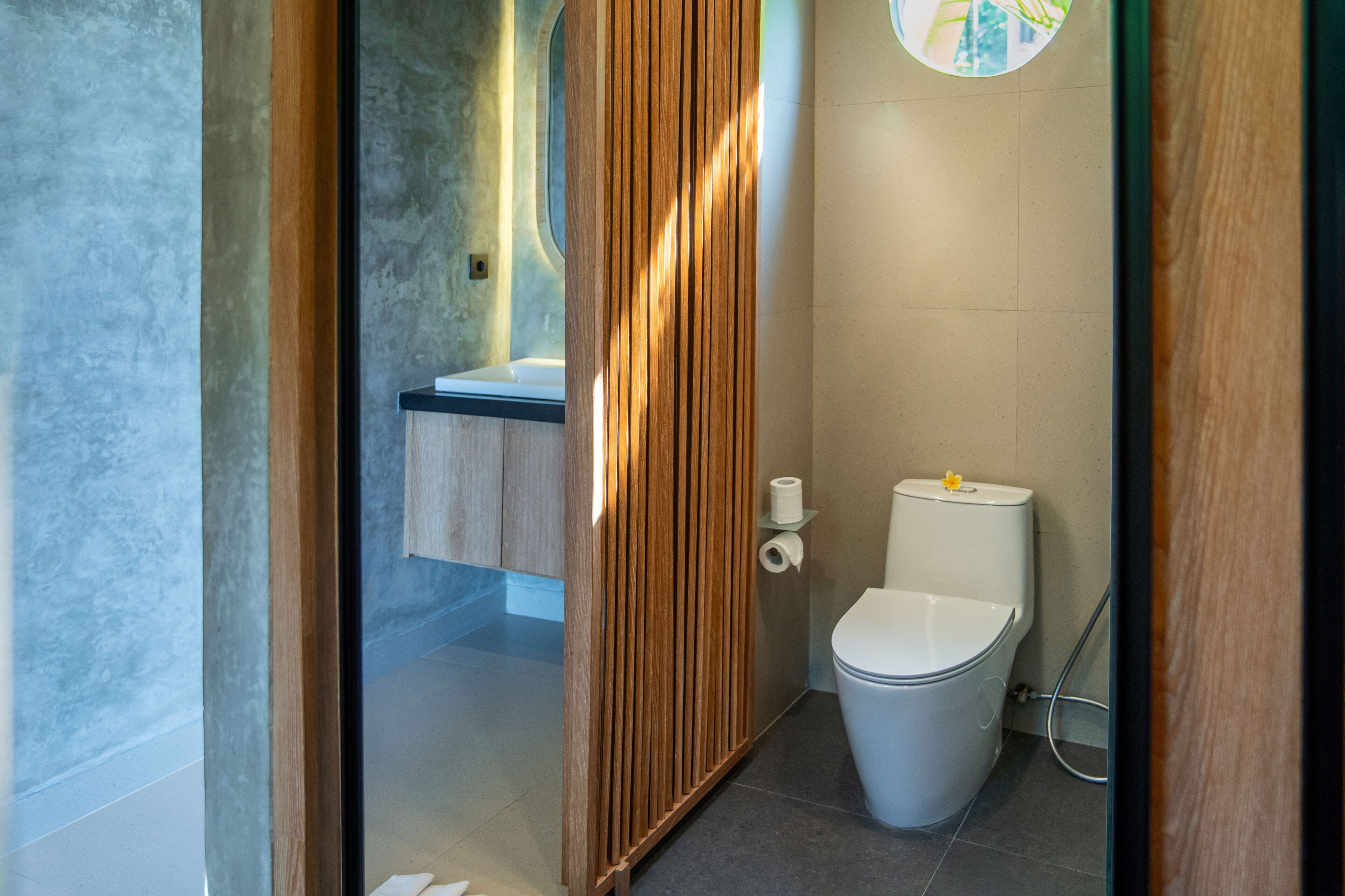 Un baño moderno con inodoro, lavabo y ducha.