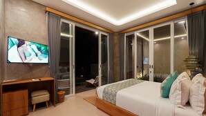 A modern bedroom with a large bed, a TV, a desk, and a sliding glass door leading to a balcony. - Subu Utamas Villas (Payangan)
