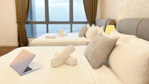 Ένα δωμάτιο ξενοδοχείου με ένα κρεβάτι, έναν φορητό υπολογιστή και θέα στην πόλη.