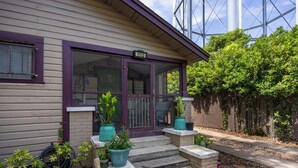 A house with a purple door and windows, a front porch with steps, and potted plants. - Luxury Retreat Just Steps from UF Main Campus (Gainesville)