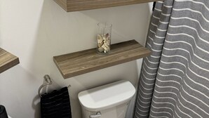 A bathroom with a toilet, a sink, and a shower curtain.