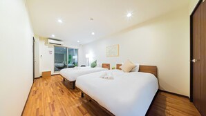 A hotel room with two beds, wooden flooring, a large window, and a door leading to a balcony. - STARRY STAY HOUSE SHIBUYA I (Tokyo)