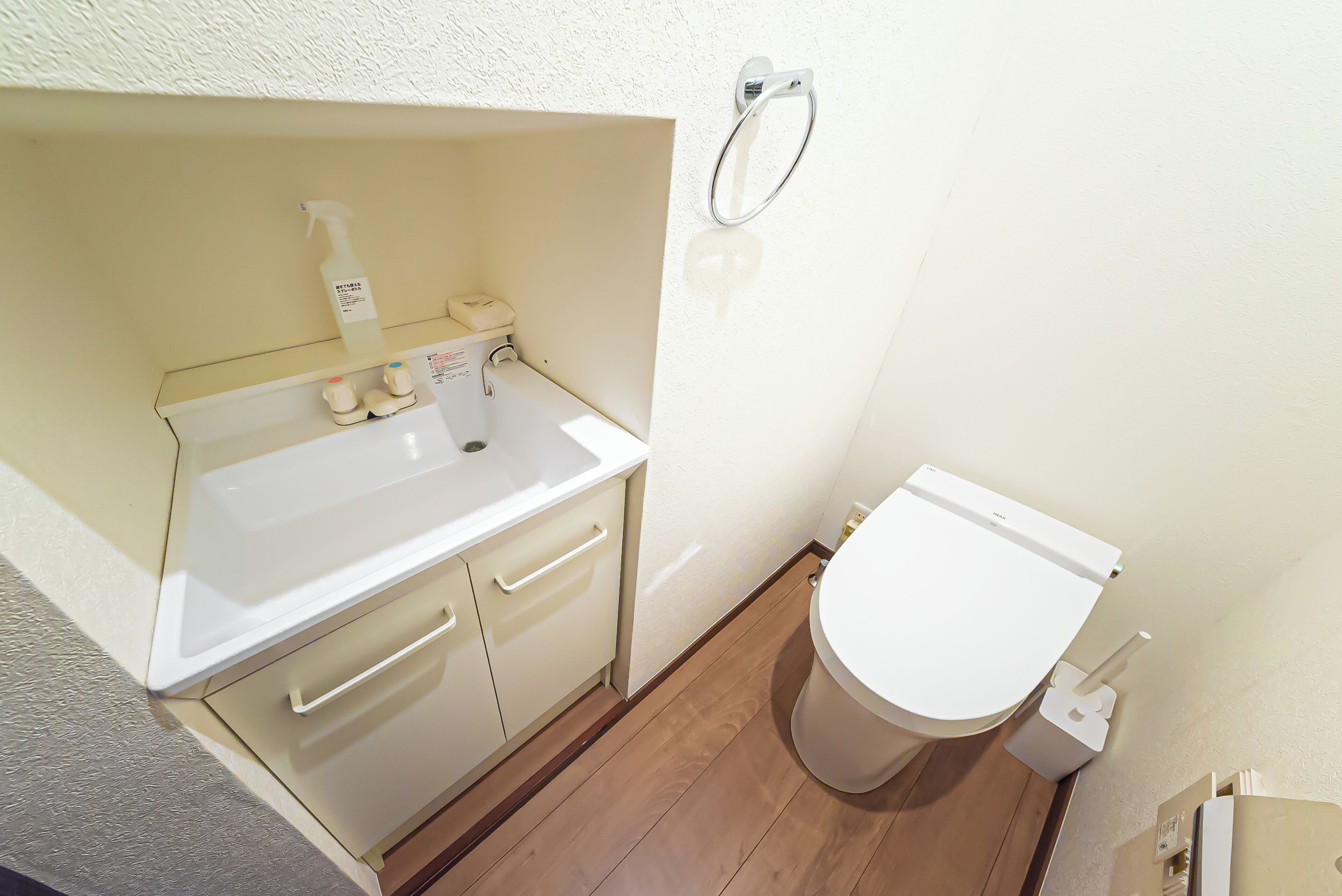 A small bathroom with a white sink, a toilet, and a towel rack.