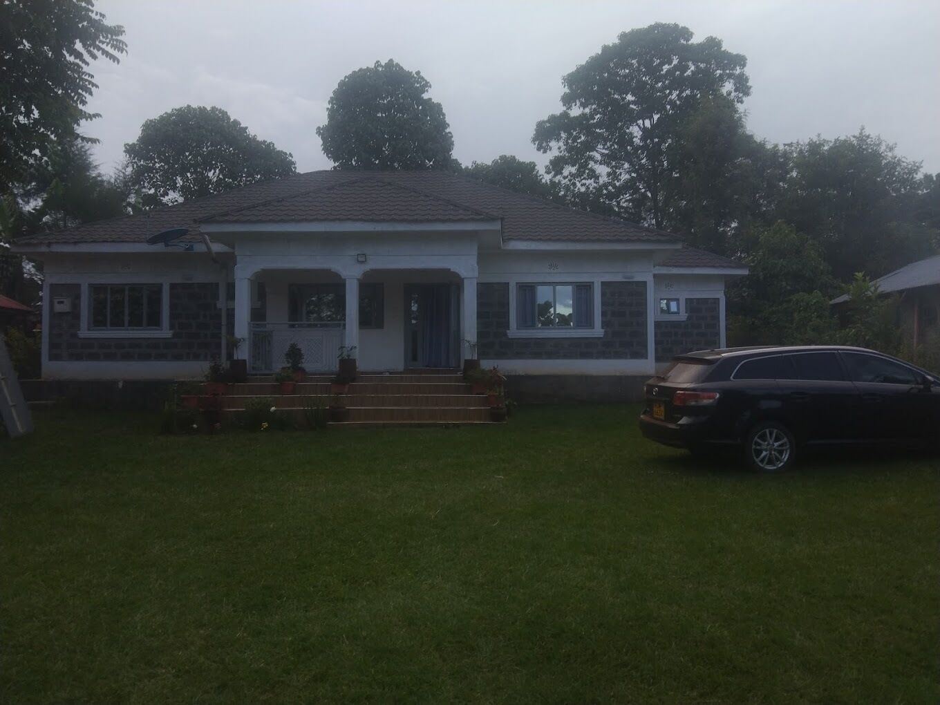 A two-story house with a front porch, a garage, and a driveway.