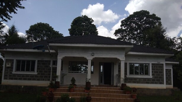 A two-story house with a front porch, a stone facade, and a dark roof. - Lux Suites Siyoi Gardens Kitale (Kitale)
