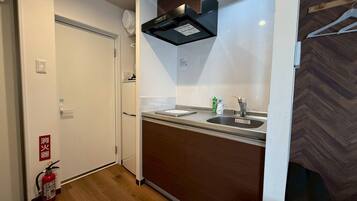 Kamer | Privékeuken | Een microgolfoven, een kookplaat, kookgerei, borden en bestek