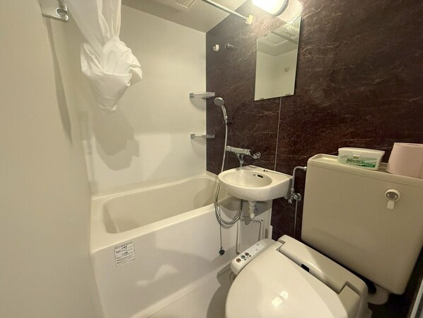 A bathroom with a bathtub, sink, and toilet. - NeXay Miebashi (Naha)