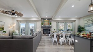 A spacious living area with a fireplace, dining table, and modern furniture.