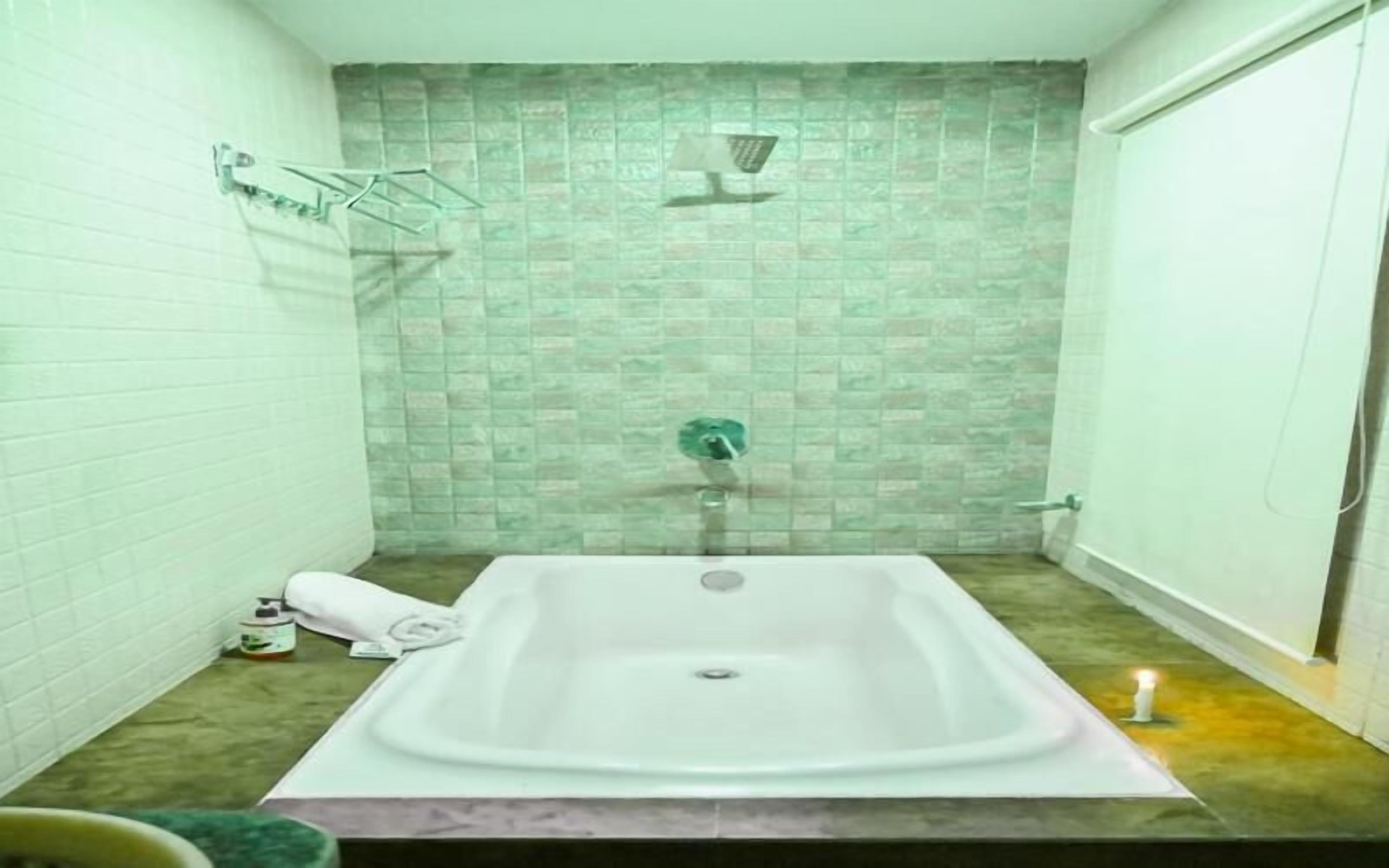 A bathroom with a freestanding bathtub, a towel rack, and a showerhead.
