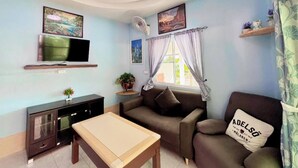 A living room with a TV, sofa, and a table.