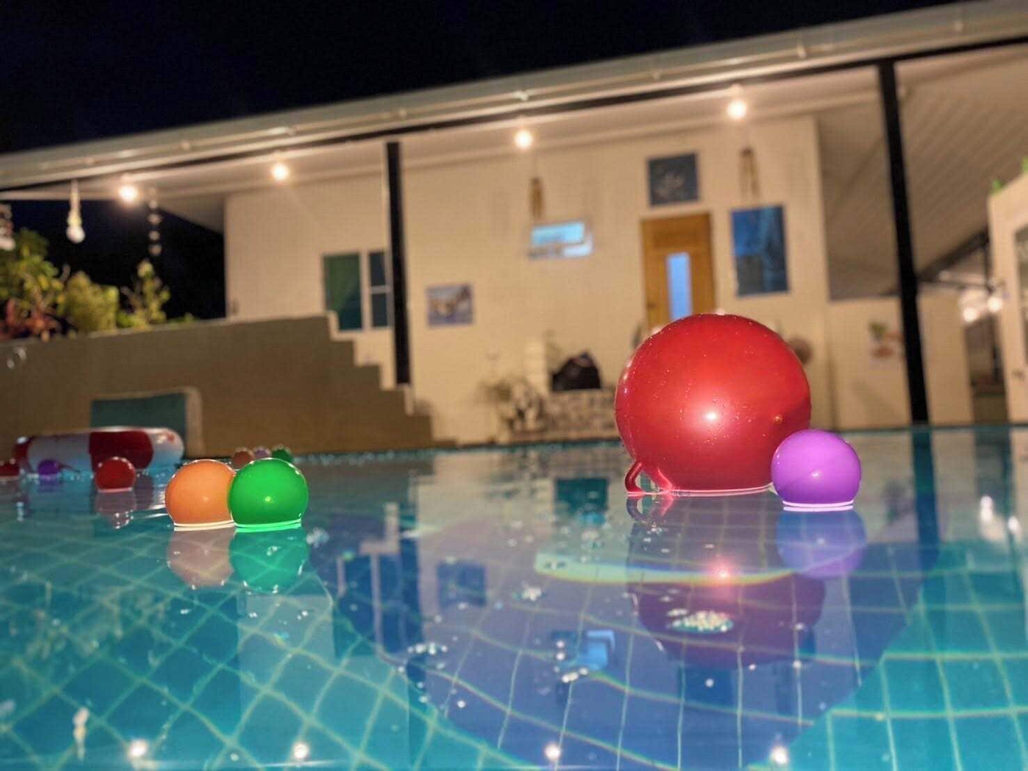 Una piscina con suelo de baldosas y un edificio al fondo.
