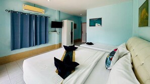 A hotel room with a large bed, a TV, a wardrobe, and a painting on the wall.