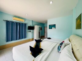 A hotel room with a large bed, a TV, a wardrobe, and a painting on the wall.