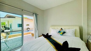 A hotel room with a bed, a view of the outside, and a balcony.