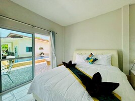 Habitación de hotel con cama, vistas al exterior y balcón.