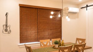 A dining area with a wooden table, chairs, a hanging light fixture, and a guitar on the wall. - Luxury 3BR/4BA townhome with 2 Car Garage in Nashville and close to the Airport. (Nashville)