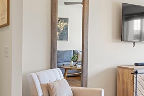 A modern living room with a sofa, a coffee table, and a TV mounted on the wall.