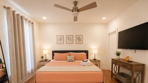 A bedroom with a bed, bedside tables, a ceiling fan, a TV, and a window with curtains. - Luxury 3BR/4BA townhome with 2 Car Garage in Nashville and close to the Airport. (Nashville)