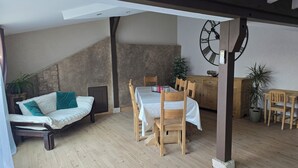 A cozy room with a bed, a dining table with chairs, and a wooden cabinet. - Beautiful Alsatian house on the wine route, at the foot of Haut-Koenigsbourg (Rorschwihr)