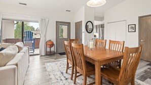 A dining area with a wooden table and chairs, a globe on a stand, and a view of the outdoors through a sliding door. - Modern Condo with Sopris Views in Downtown Carbondale (Carbondale)