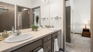 A modern bathroom with two sinks, a large mirror, and a vanity with drawers. - Modern Condo with Sopris Views in Downtown Carbondale (Carbondale)