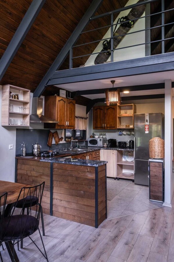 A modern kitchen with wooden cabinetry, a central island, and stainless steel appliances.