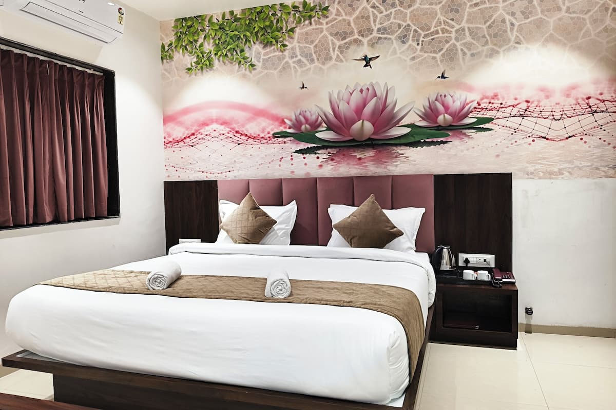 A bedroom with a bed, a nightstand, and a wall mural.