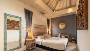 Ein Schlafzimmer mit einem großen Bett, einem Holzkopfende, Nachttischen mit Lampen, einem Spiegel und einem Wandheizkörper.