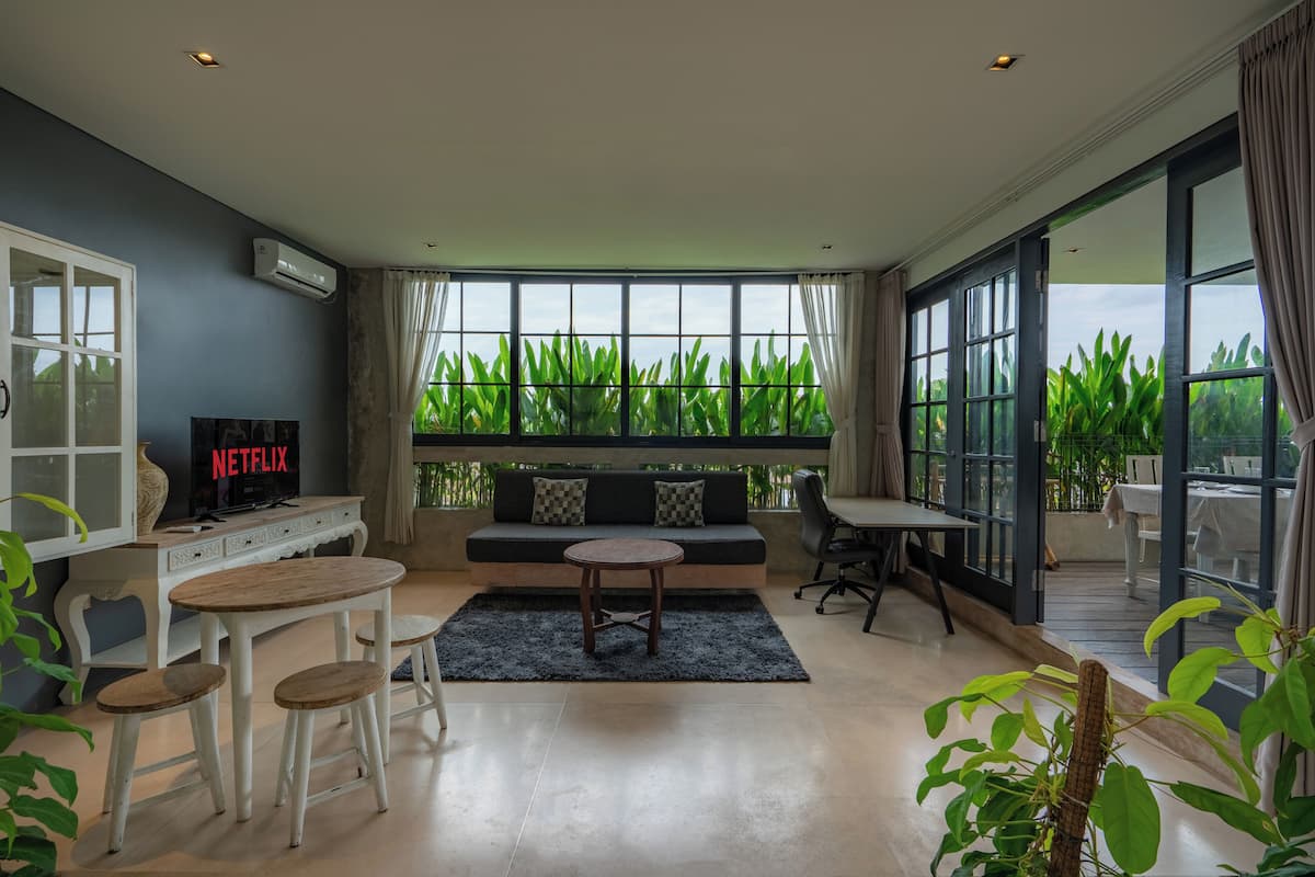 A modern living room with a sofa, a coffee table, and a TV displaying 'NETFLIX'.