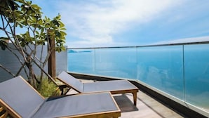 Een balkon met loungestoelen met uitzicht op een waterpartij.