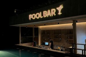 Eine Poolbar mit einer Neonreklame, einem Barkeeper und einer Bar.