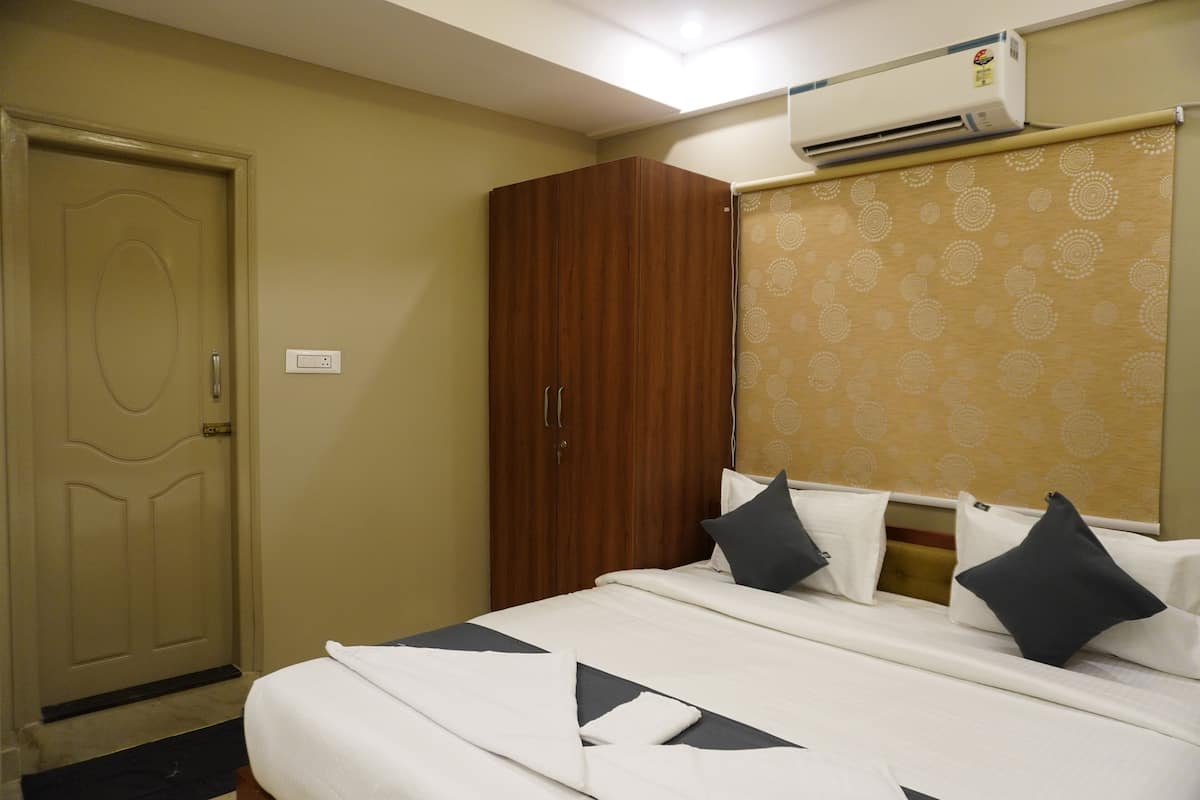 Une chambre d’hôtel équipée d’un lit, d’une armoire et d’un climatiseur fixé au mur.
