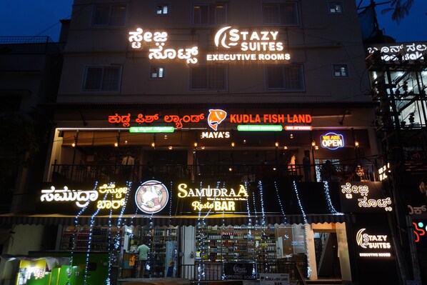 A building with multiple signs including "Stazy Suites Executive Rooms" and "Samudraa Resto BAR". - Stazy Suites - Kammanhalli (Bengaluru)