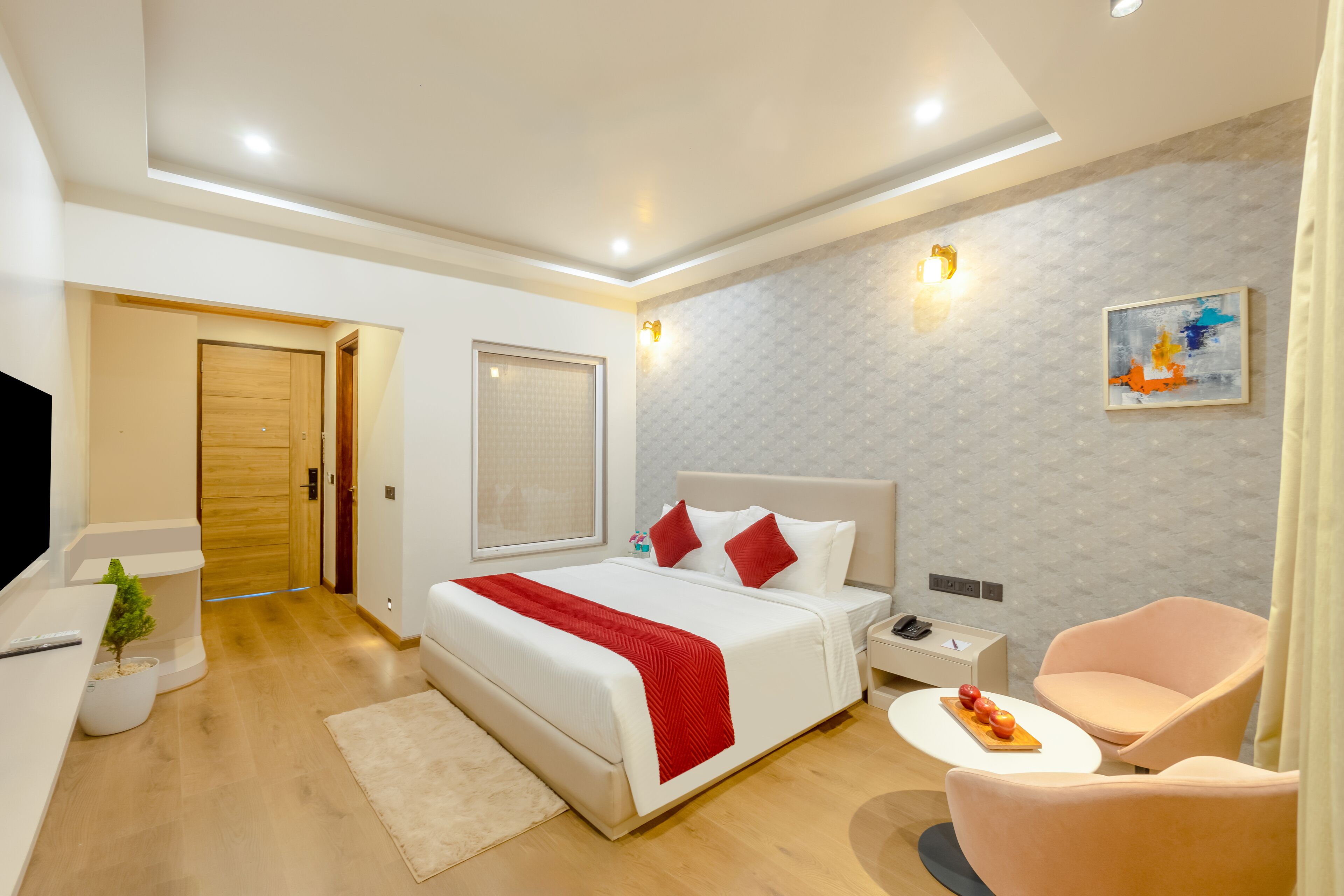 Une chambre d’hôtel moderne dotée d’un grand lit, de tables de chevet, d’un bureau et d’un coin salon.