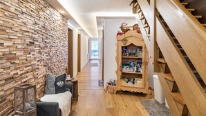 Un corridoio con parete in legno, una scala e una libreria.