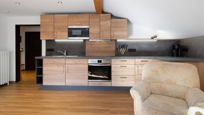 A modern kitchen with wooden cabinets, a built-in oven, and a countertop.