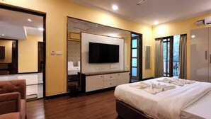A hotel room with a bed, a TV, a wardrobe, and a bathroom visible through an open door. - CALANGUTE BEACH VILLA By SEVEN HOTELS (Calangute)
