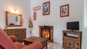 A living room with a fireplace, a television, and a sofa. - Ibipozo Vacation Home With Pool (Pozo Alcon)