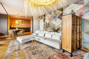 Una sala moderna con un sofá modular, una mesa de centro, un mueble de madera y un comedor con sillas y una mesa.